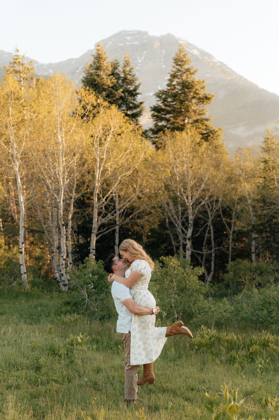 Phillip lifting Grayce with the mountain behind